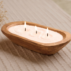 Ivory pearled candle wax in a wooden bowl with three lit wicks
