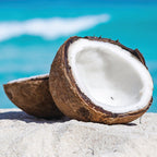 Halved coconut on a sandy beach