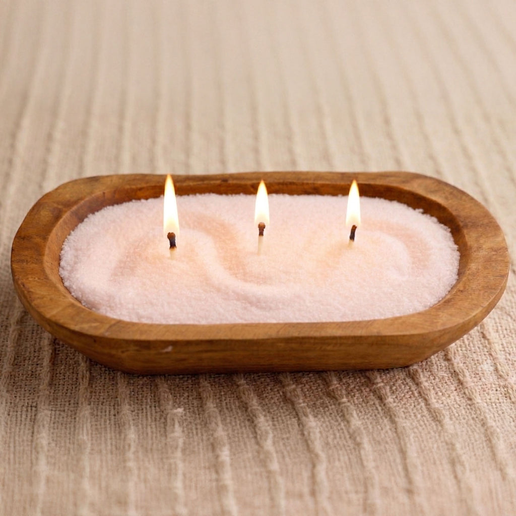 Wooden bowl candle made with pink pearled candle wax and three lit wicks