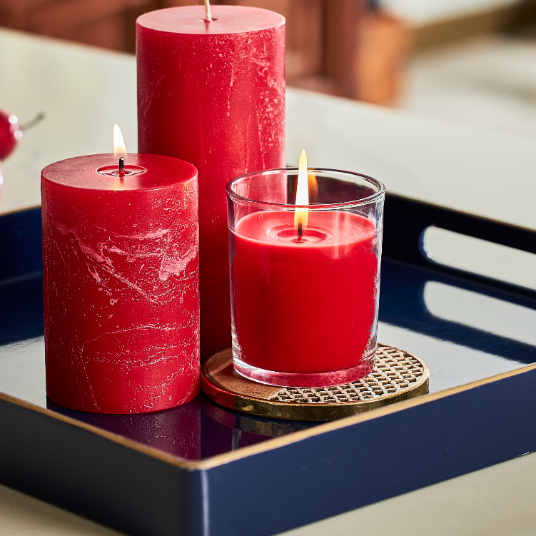Red candle in a 7 oz clear jar with red pillar candles on a tray