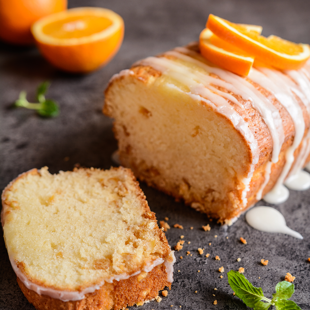 Glazed orange pound cake slices with fresh oranges