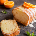 Glazed orange pound cake slices with fresh oranges